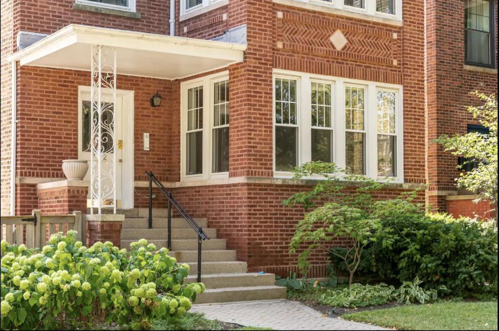 una casa de ladrillo con una puerta blanca y escaleras en Lovely Family Friendly Home- Free Parking, en Evanston