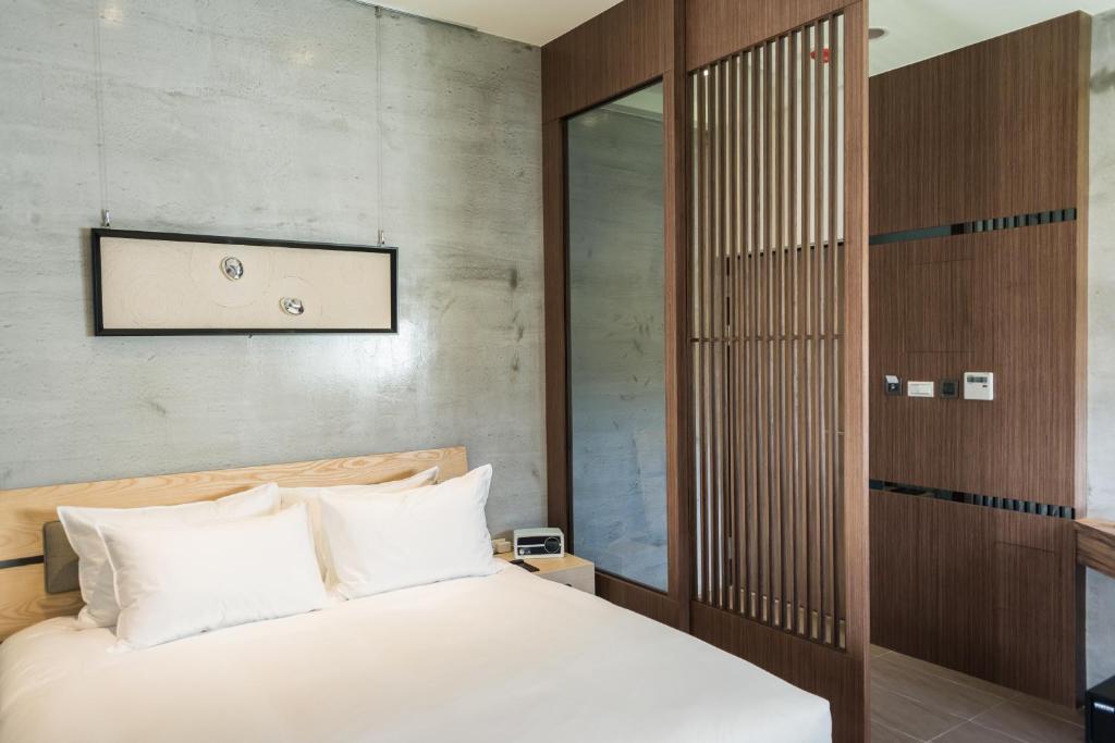 a bedroom with a bed with white pillows at The Silence Manor in Ruisui