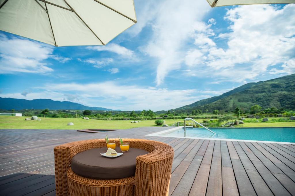 a table and chairs on a wooden deck with an umbrella at The Silence Manor in Ruisui