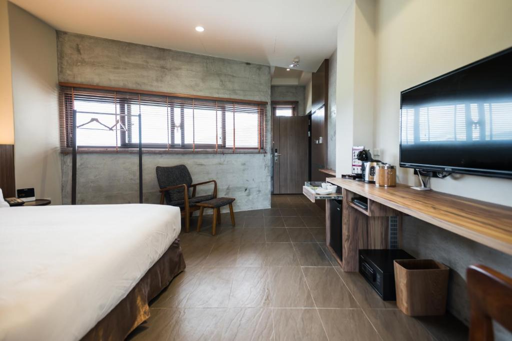 a hotel room with a bed and a flat screen tv at The Silence Manor in Ruisui