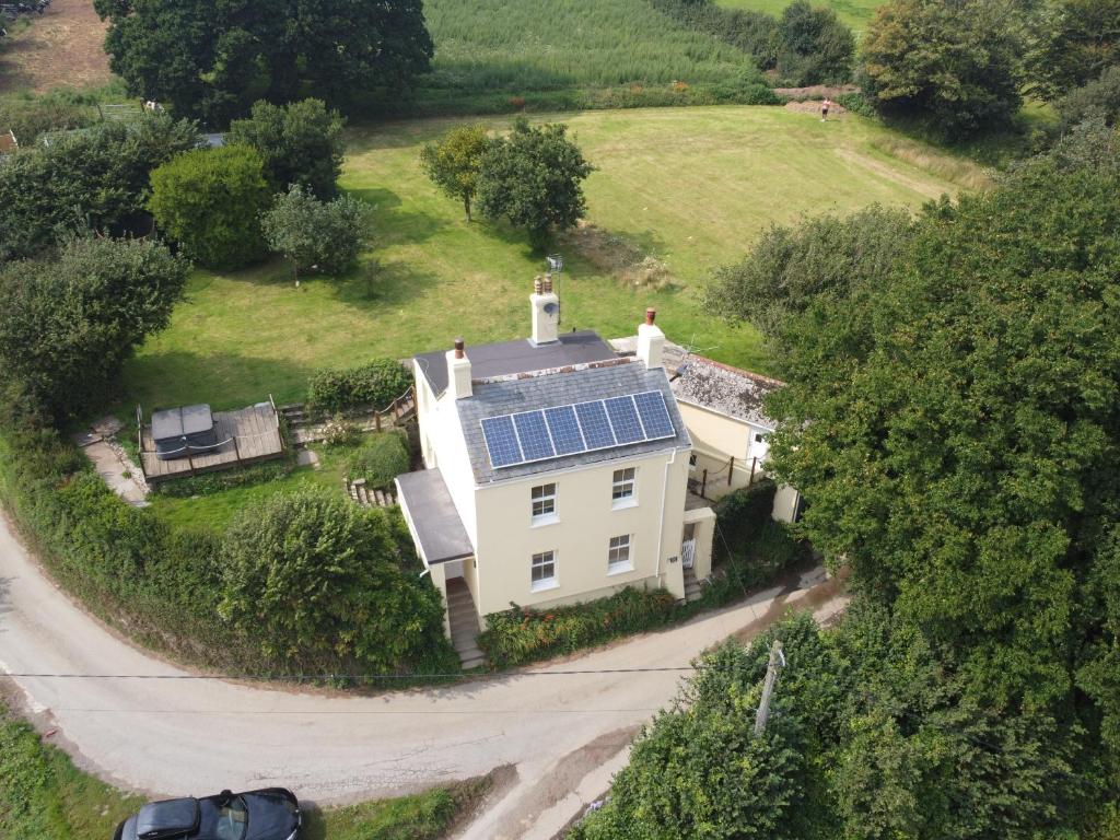 an aerial view of a house with solar panels on it at Clotted Cream Cottage: Countryside calm: Close to beach: Dartmouth: Devon in Dartmouth