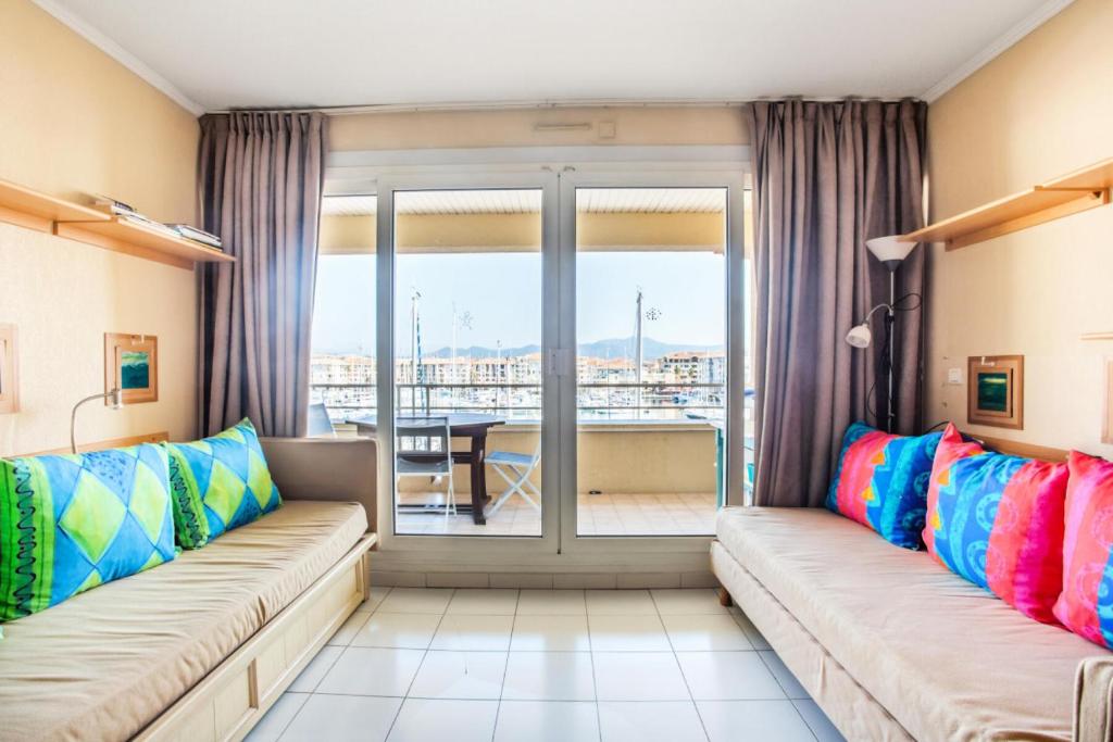 un salon avec deux canapés et une grande fenêtre dans l'établissement Résidence Cap Hermes - maeva Home - Appartement 2 Pièces 4 Personnes - Selection MAE-4143, à Fréjus