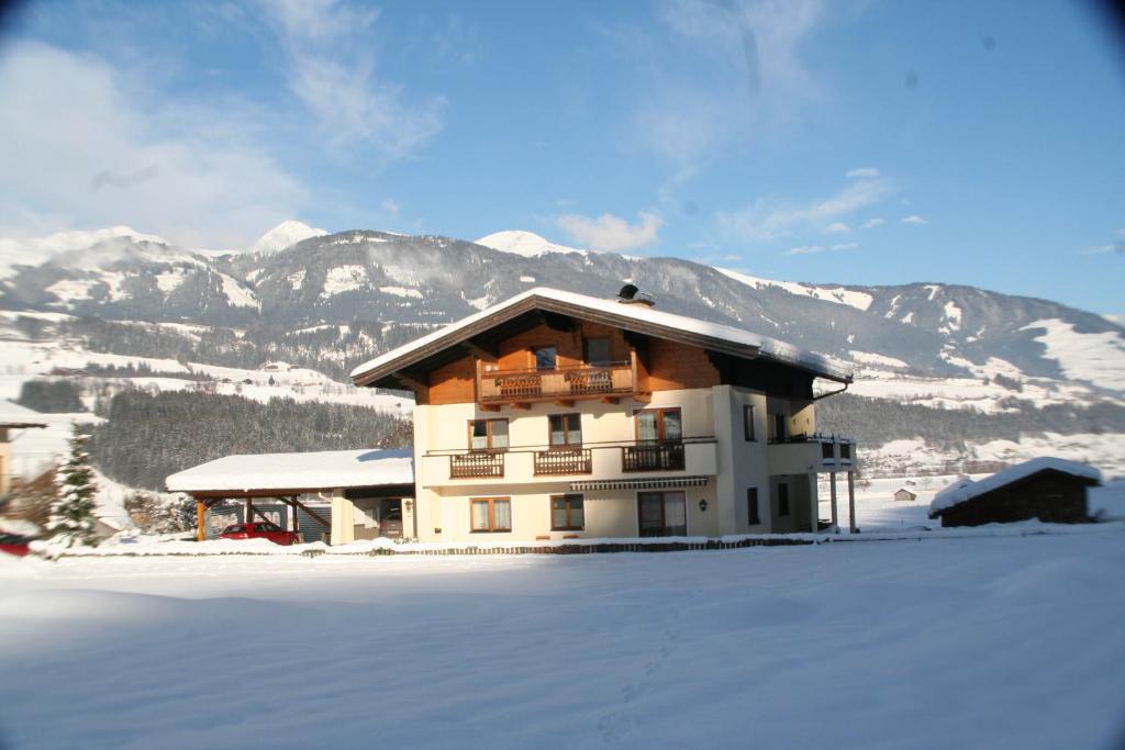 a building in the snow with mountains in the background at Oase der Ruhe in Hollersbach im Pinzgau