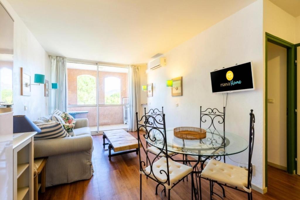 uma sala de estar com uma mesa de vidro e um sofá em Résidence Saint-Raphaël Valescure - maeva Home - Appartement 3 Pièces 6 Pe 75 em Valescure