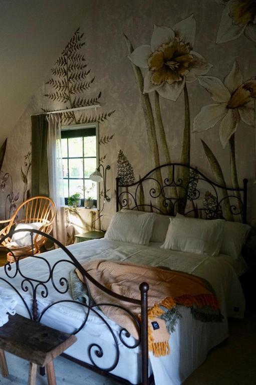 a bedroom with a bed with flowers on the wall at Boutiquehotell Dahlbogården in Alingsås