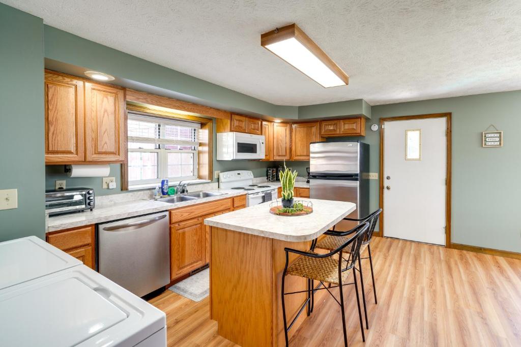 a kitchen with wooden cabinets and a table with chairs at Cozy West Virginia Home about 13 Mi to Kanawha River in Hurricane