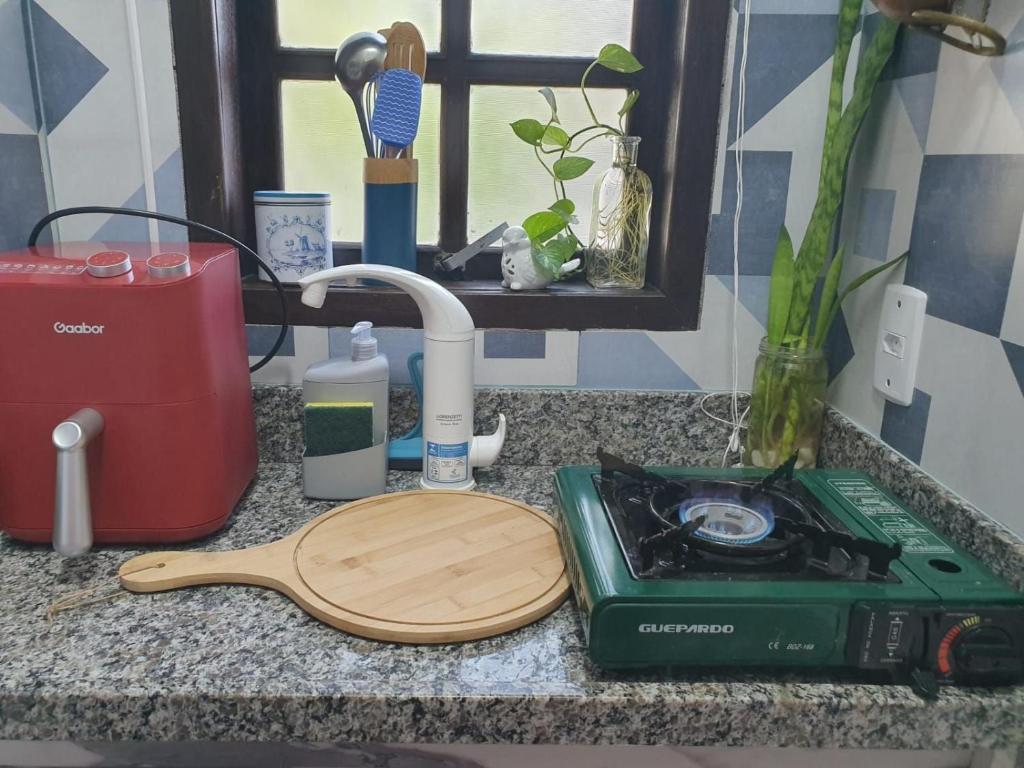 encimera de cocina con tabla de cortar y fregadero en Andorinhas "Mini casa de hóspede" en Niterói