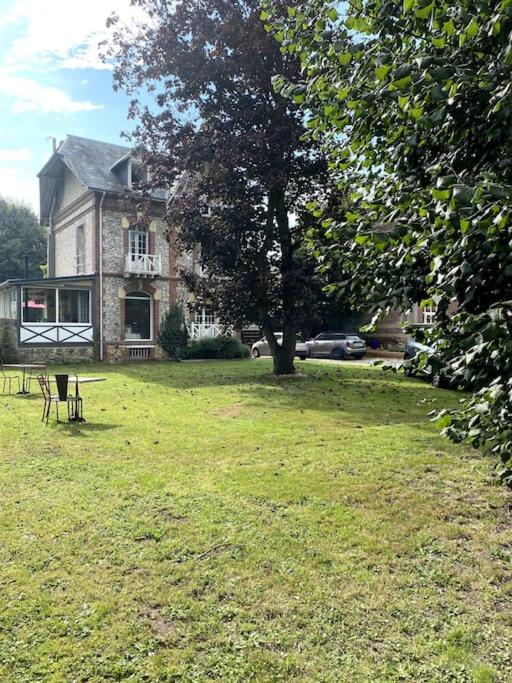 une maison avec un arbre en face d'une cour dans l'établissement La Villa Lumaga, à Étretat