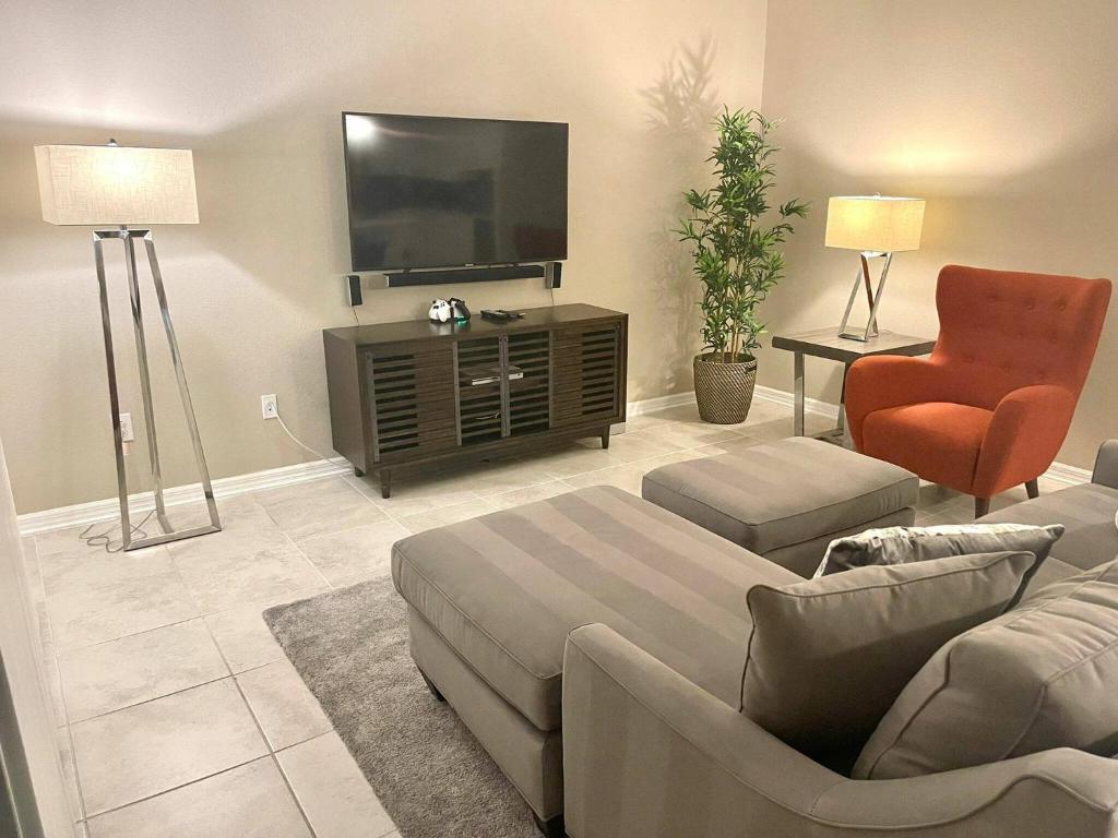 - un salon avec un canapé et une télévision dans l'établissement Stunning Apartment at Storey Lake SL47317, à Kissimmee