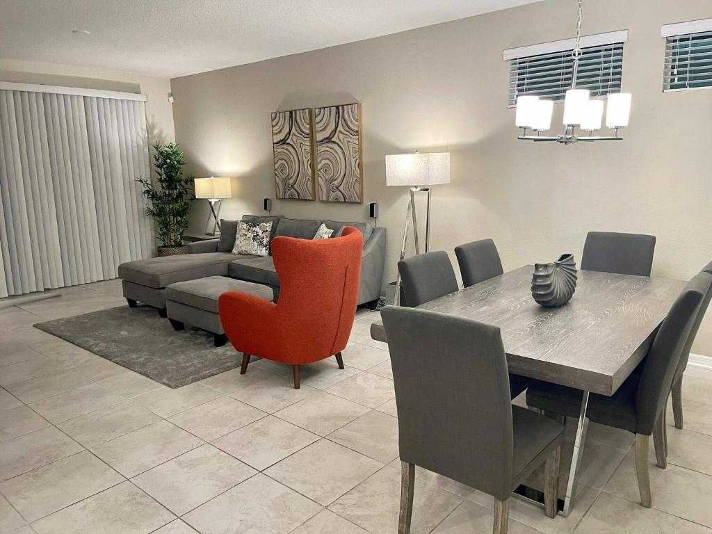 sala de estar con mesa, sillas y sofá en Awesome Apartment at Storey Lake SL47318, en Kissimmee