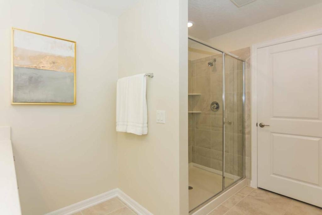 uma casa de banho com um chuveiro e uma cabina de duche em vidro. em Dream Apartment at Storey Lake SL47311 em Kissimmee