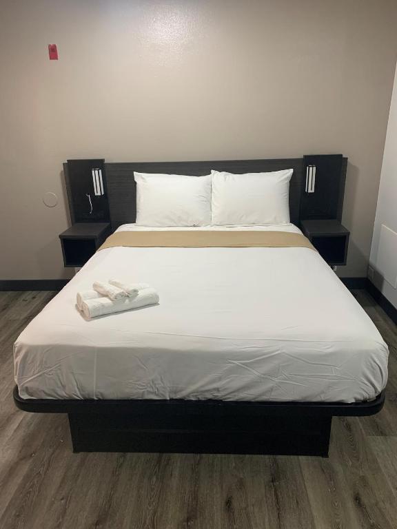 Una cama con dos toallas blancas encima. en HomeStay Lodge en Pensacola