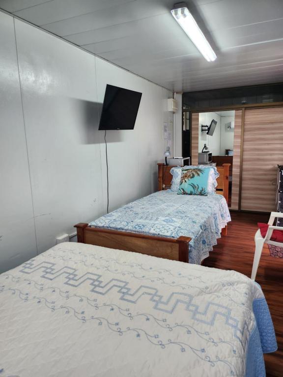 a bedroom with two beds and a flat screen tv at Bonvivant Boquete in Alto Boquete