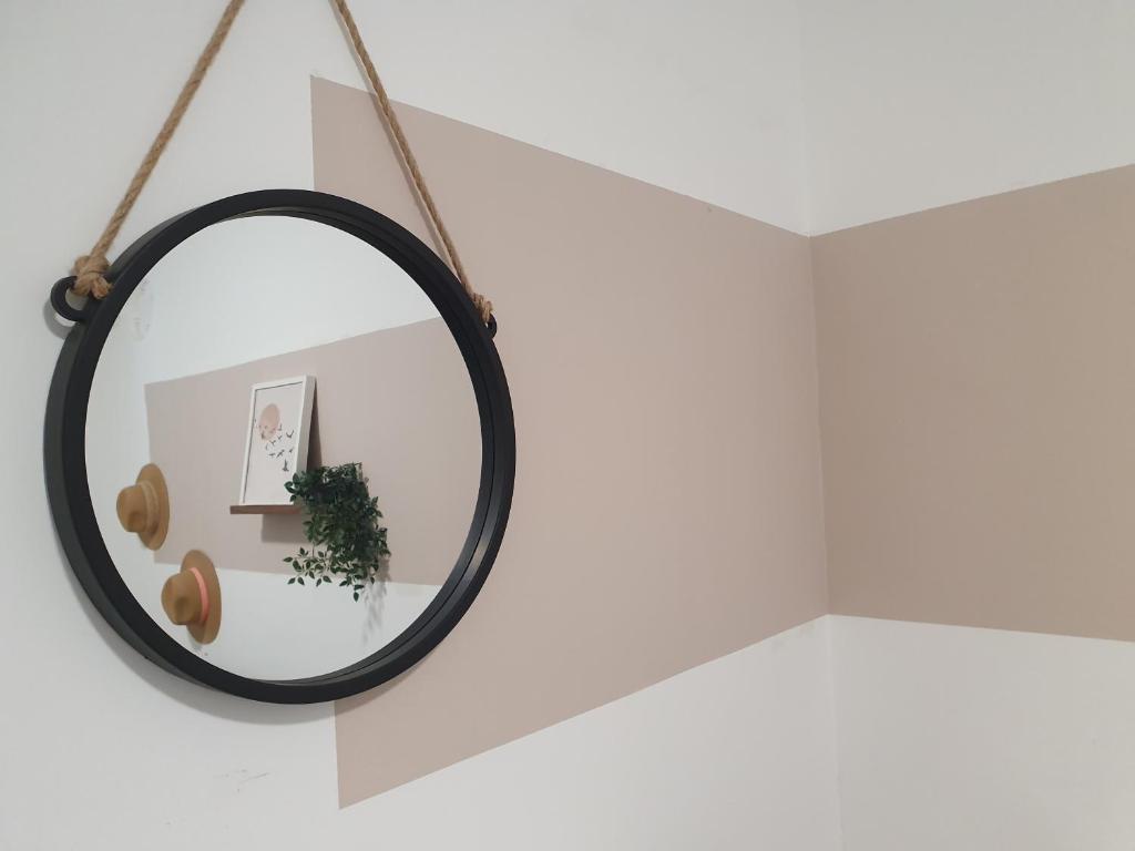 a round mirror hanging on a white wall at וילה אל מול גלעד in Reẖov