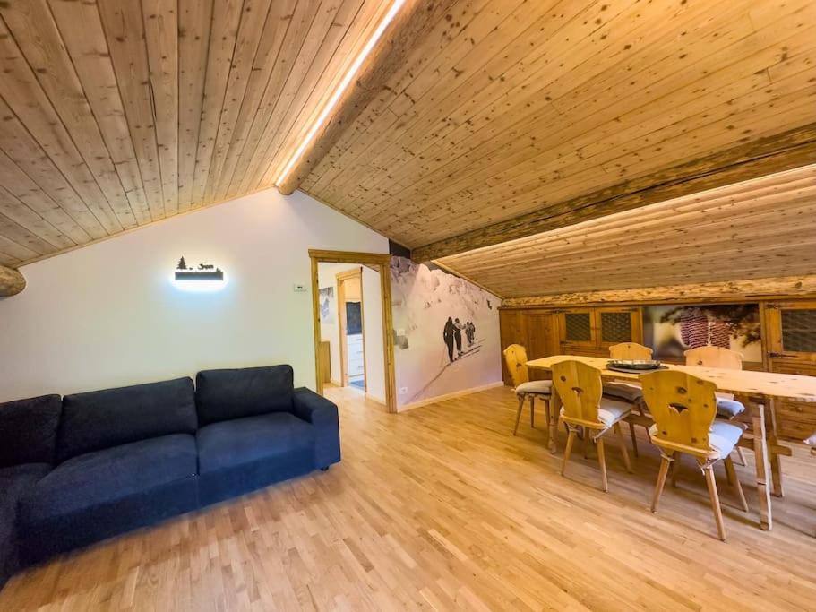 uma sala de estar com um sofá azul e uma mesa em Bormio House con vista pista Stelvio em Bormio