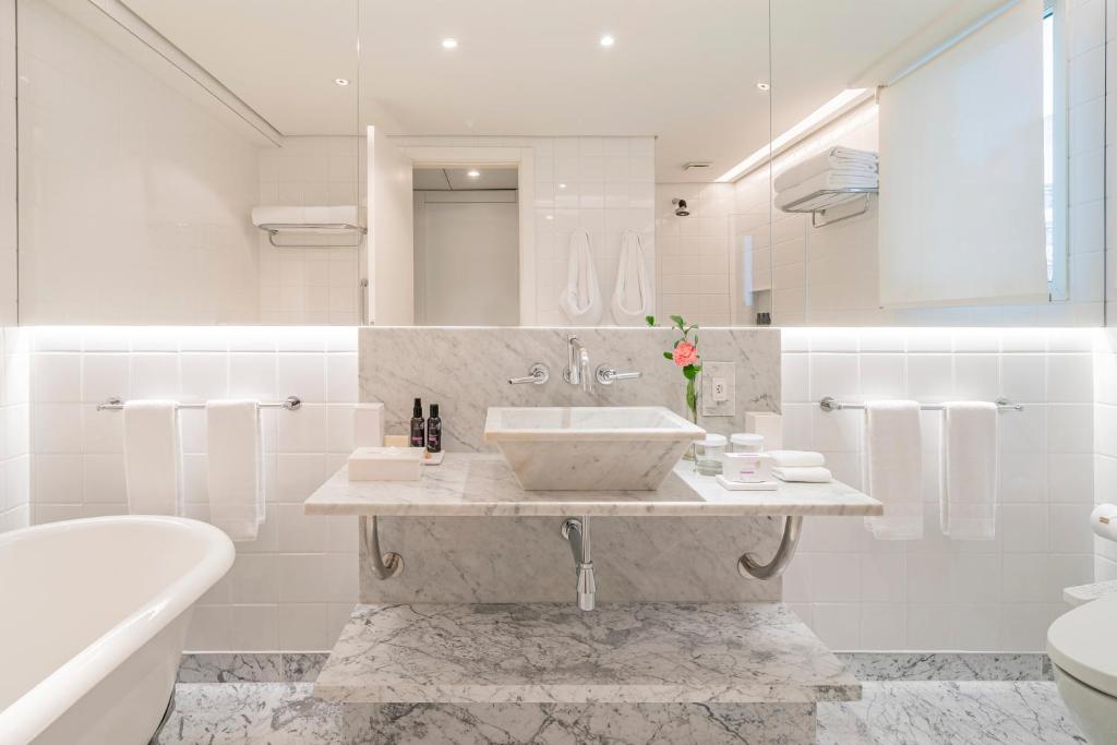 a bathroom with a sink and a toilet and a tub at Hotel Emiliano in Sao Paulo