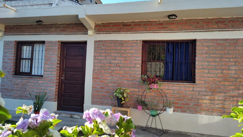 a brick house with two windows and a basket of flowers at EcoNina in Salta