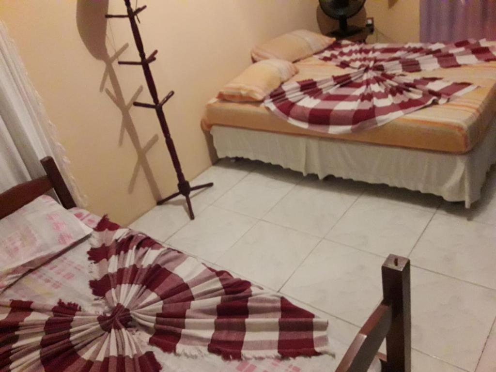 una camera con 2 letti e un tavolo con ventilatore di Casa temporada maricá a Maricá