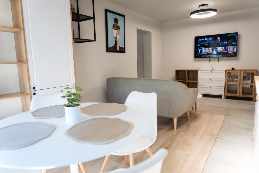 a dining room with a white table and chairs at Apartament 209 in Alba Iulia