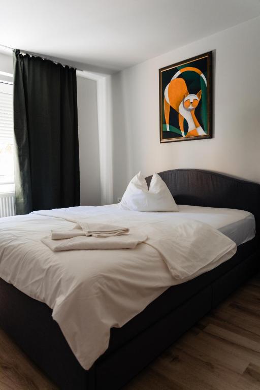 阿尔巴尤利亚Apartament 209的卧室里有一张大床，墙上挂着一幅画