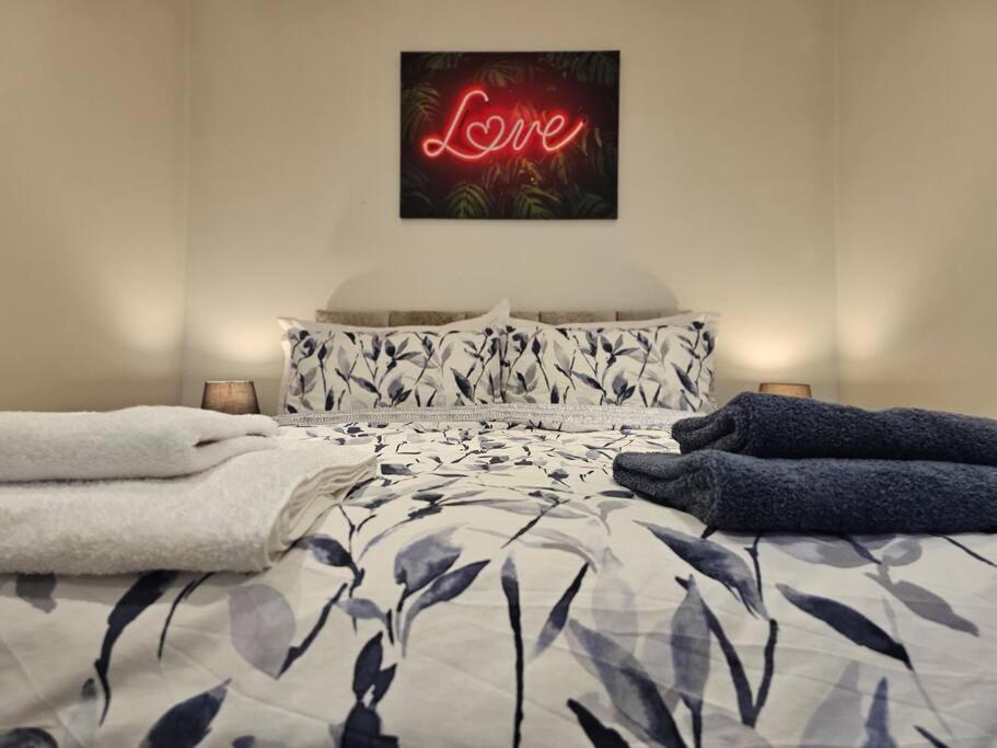 a bedroom with a bed with a sign that reads love at Your Own Ground Floor Apartment in Central Woking in Woking