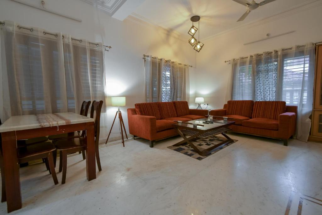 a living room with red chairs and a table at HomeSlice Hangout in Bangalore