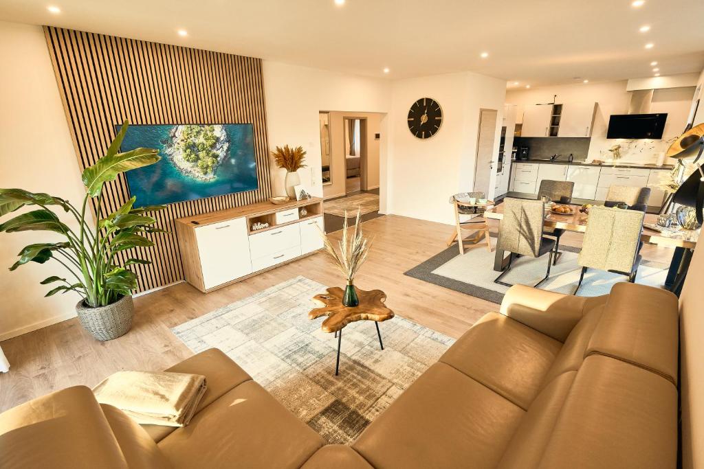 sala de estar con sofá y cocina en 118qm Traumzeit Residences am National Park Birkenfeld - Perfekt für bis zu 4 Personen en Ellweiler