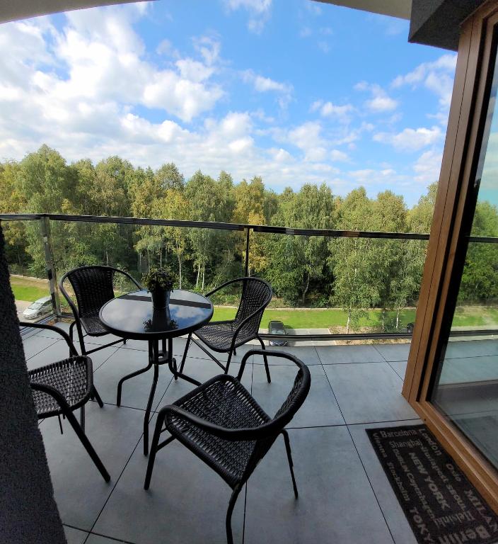 a patio with a table and chairs on a balcony at Apartament Poleska Park in Częstochowa