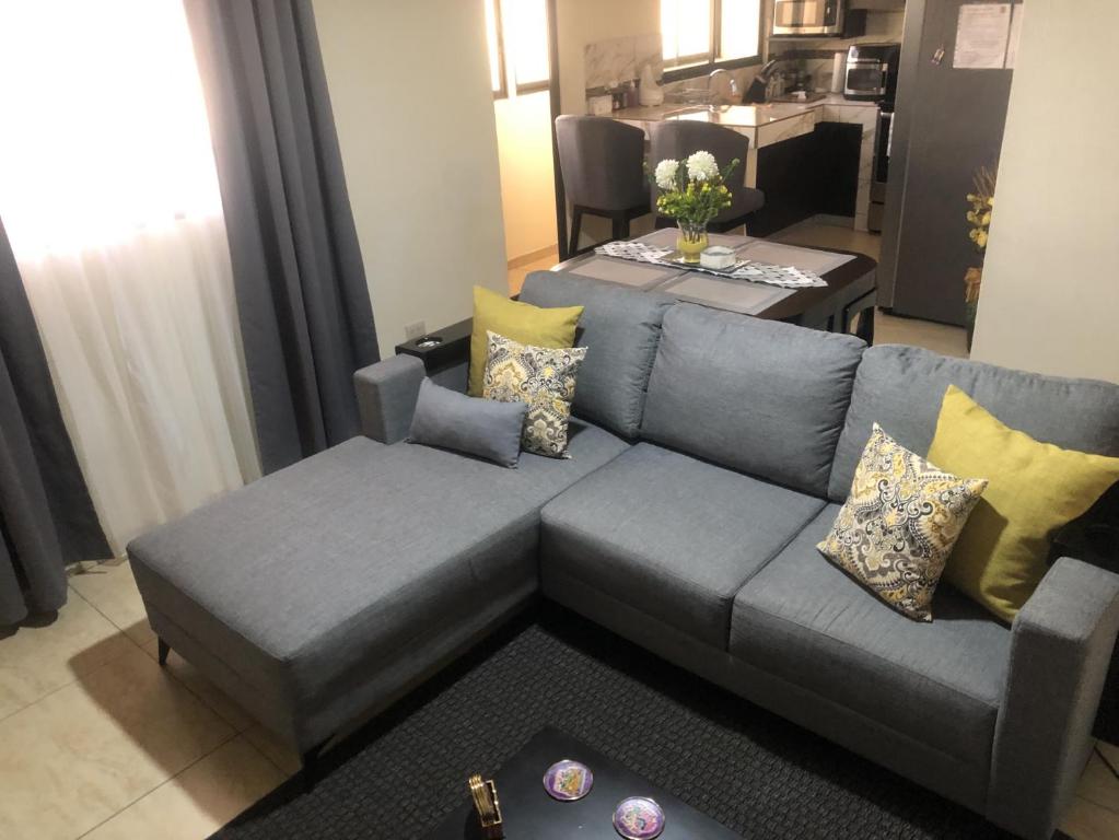 sala de estar con sofá azul y mesa en Senderos Apartment, Self Check- in, Airport SJO 5 MIN en Santiago Este