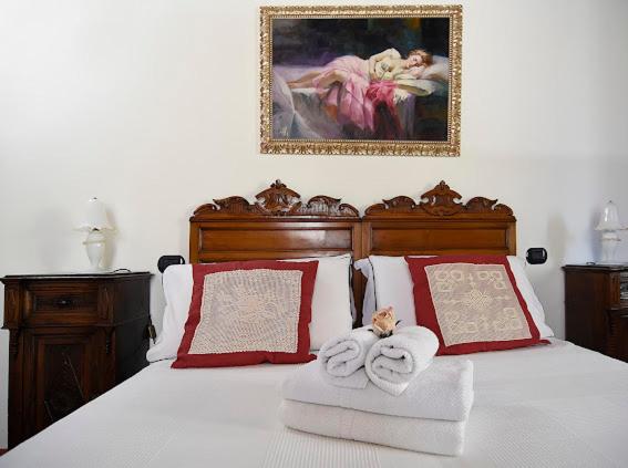 a bedroom with a bed with towels and a painting at Domus Letizia in Campora
