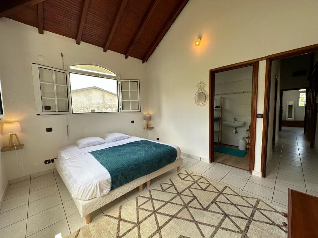 a bedroom with a large bed and a bathroom at Guadeloupe Guesthouse in Port-Louis