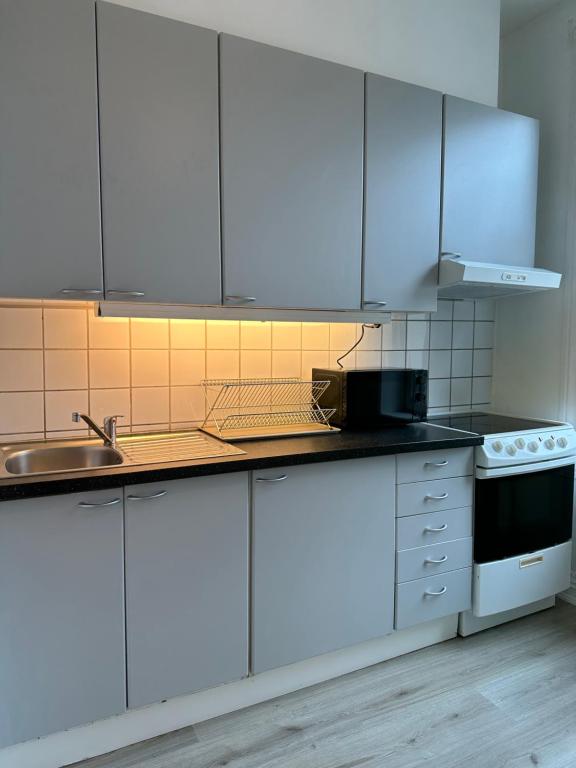a kitchen with white cabinets and a sink at Grunerløkka Apartments in Oslo