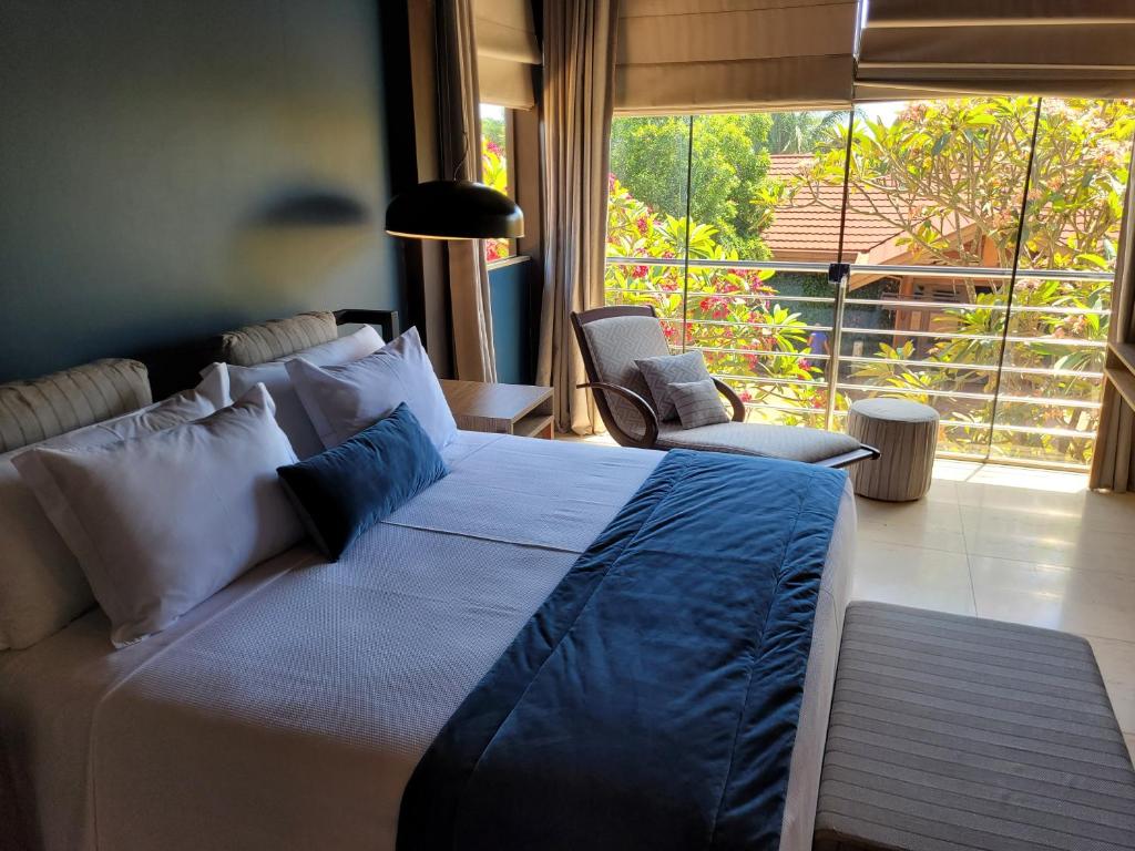 a bedroom with a large bed and a large window at Pobore SPA Pousada in Rondonópolis