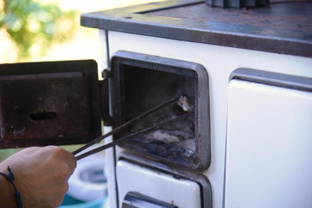 uma pessoa está colocando algo em um forno em Shpija E AMEL (Sweet Guest House) 