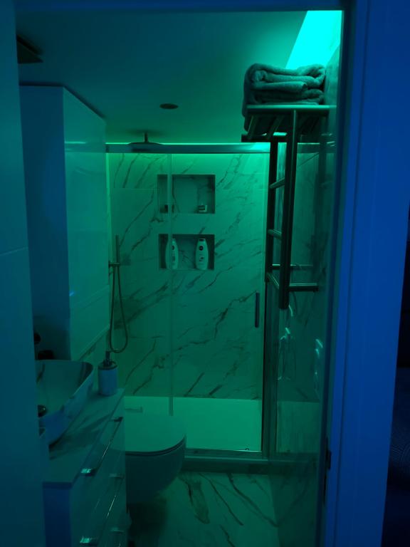 a bathroom with a glass shower with a blue light at Sweet home in Bagnolet