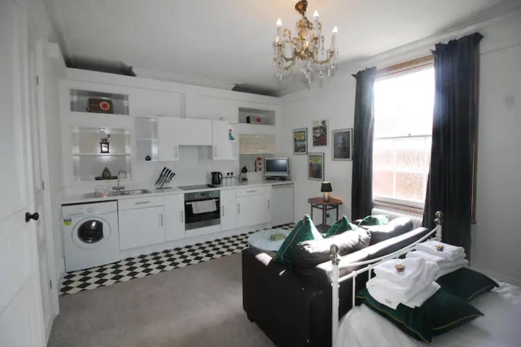 ein Wohnzimmer mit einem Sofa und einer Küche in der Unterkunft City Centre Bolt Hole Exeter in Exeter
