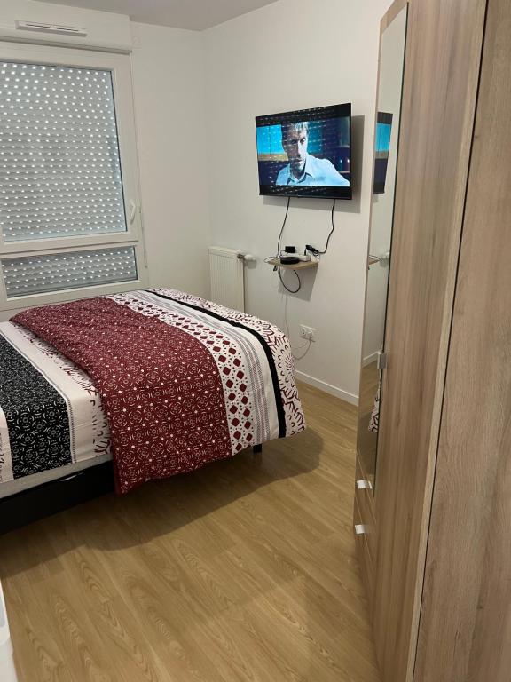 1 dormitorio con 1 cama y TV de pantalla plana en Champions home, en Sarcelles