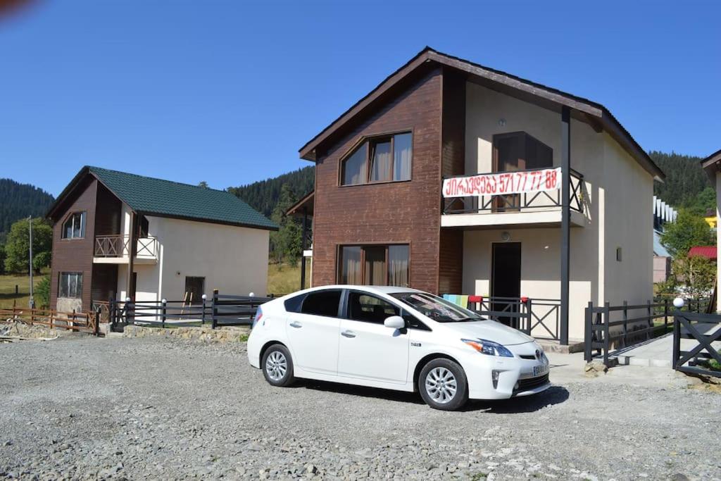 a white car parked in front of a building at SNOW HOUSE BAKURIANI! in Bakuriani