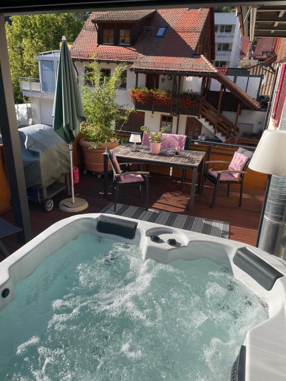 a jacuzzi tub on a patio with a table at Muggel Apartments in Alpirsbach