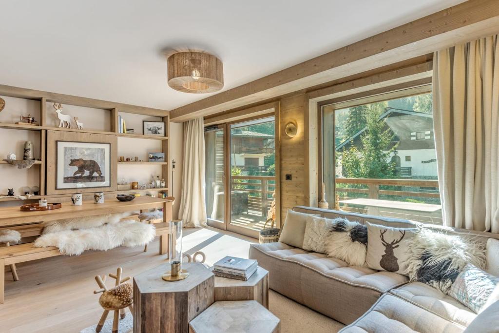 a living room with a couch and a large window at Appartement du Cerf - Welkeys in Megève