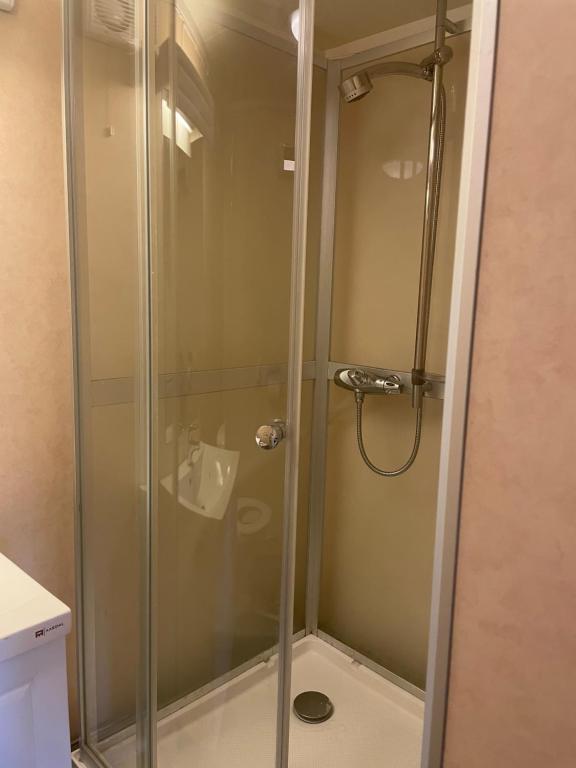 La salle de bains est pourvue d'une douche avec une porte en verre. dans l'établissement Aurora Apartment very close to Fjellheisen, à Tromsø