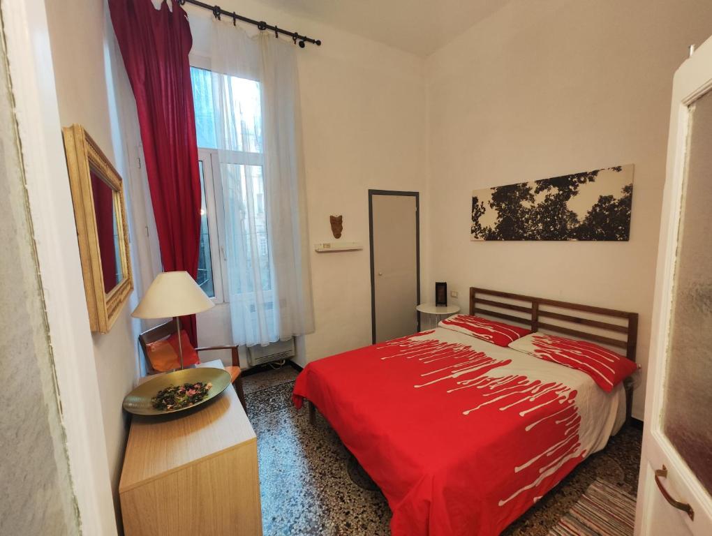 sypialnia z czerwonym łóżkiem i oknem w obiekcie Iron Home w Genui