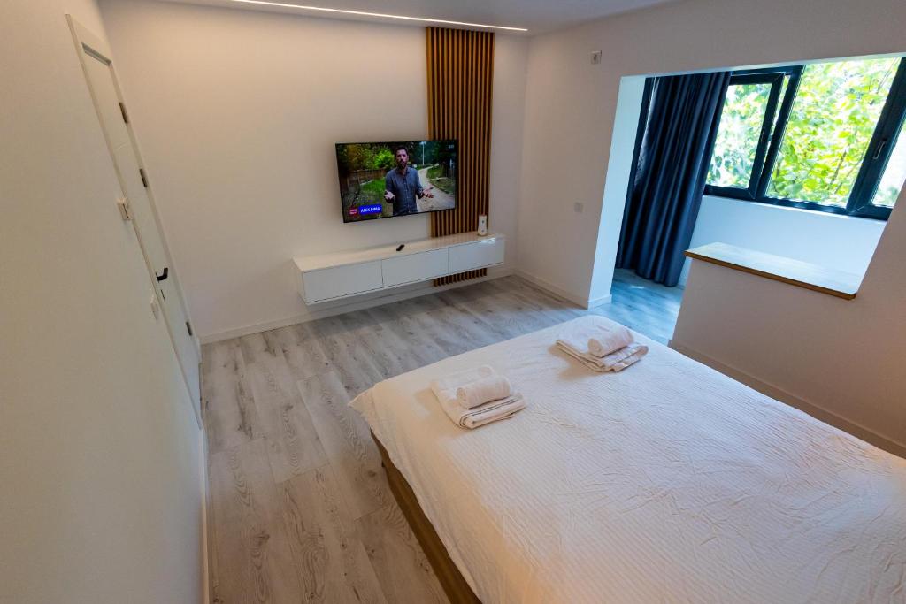 a bedroom with a bed and a tv on a wall at MODERN PREMIUM APARTMENT 1 in Târgovişte