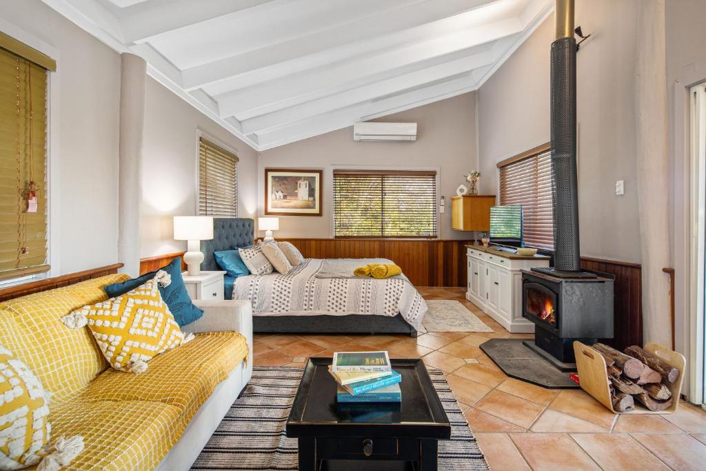 a living room with a couch and a fireplace at Brisbane River Cabin in Mount Ommaney
