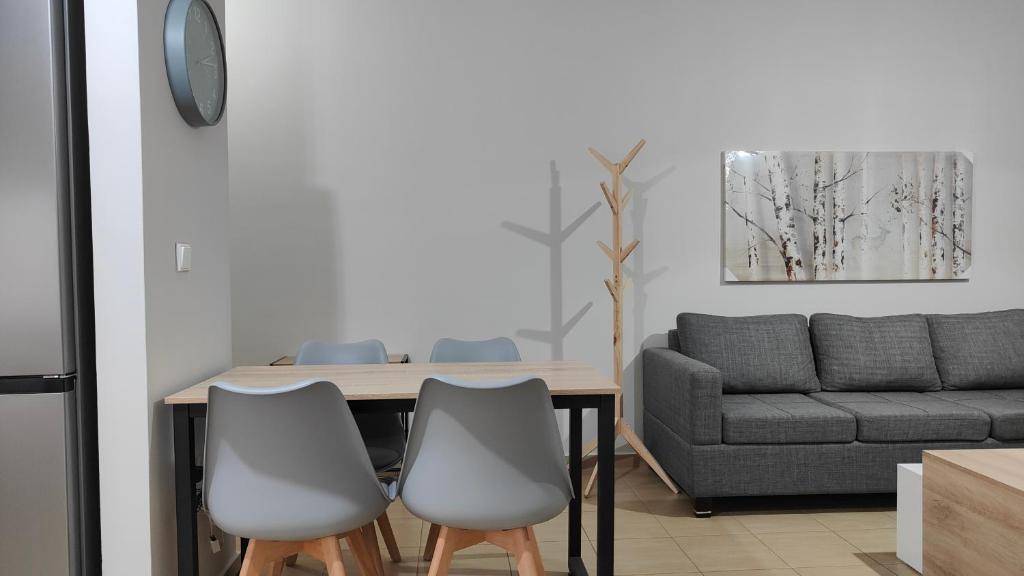 a dining room table with two chairs and a couch at Rock & Roll 1 - Modern apartment in Trikala in Tríkala