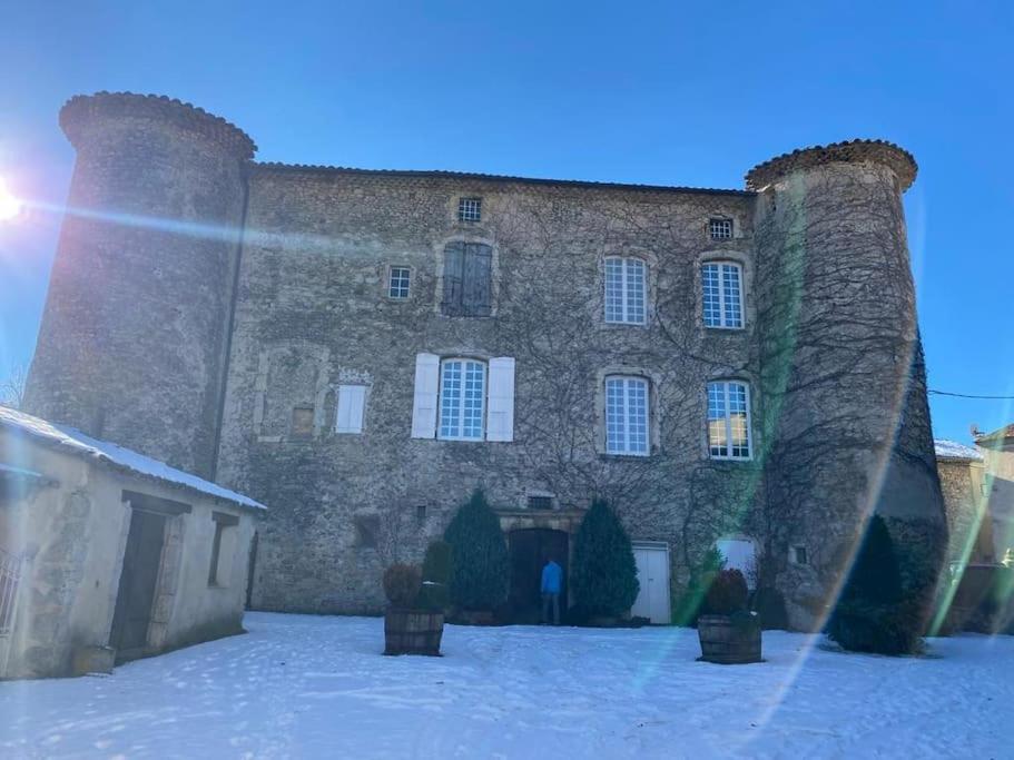 un gran edificio de ladrillo con dos torres en la nieve en Studio au château de Lachau, en Lachau