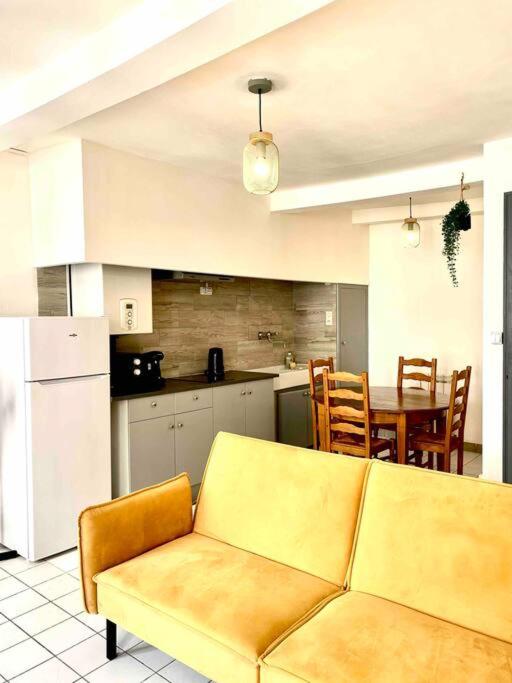 un salon avec un canapé et une cuisine avec une table dans l'établissement 2 T2 proche place Carnot BOX A BAGAGES GRATUITS, à Carcassonne