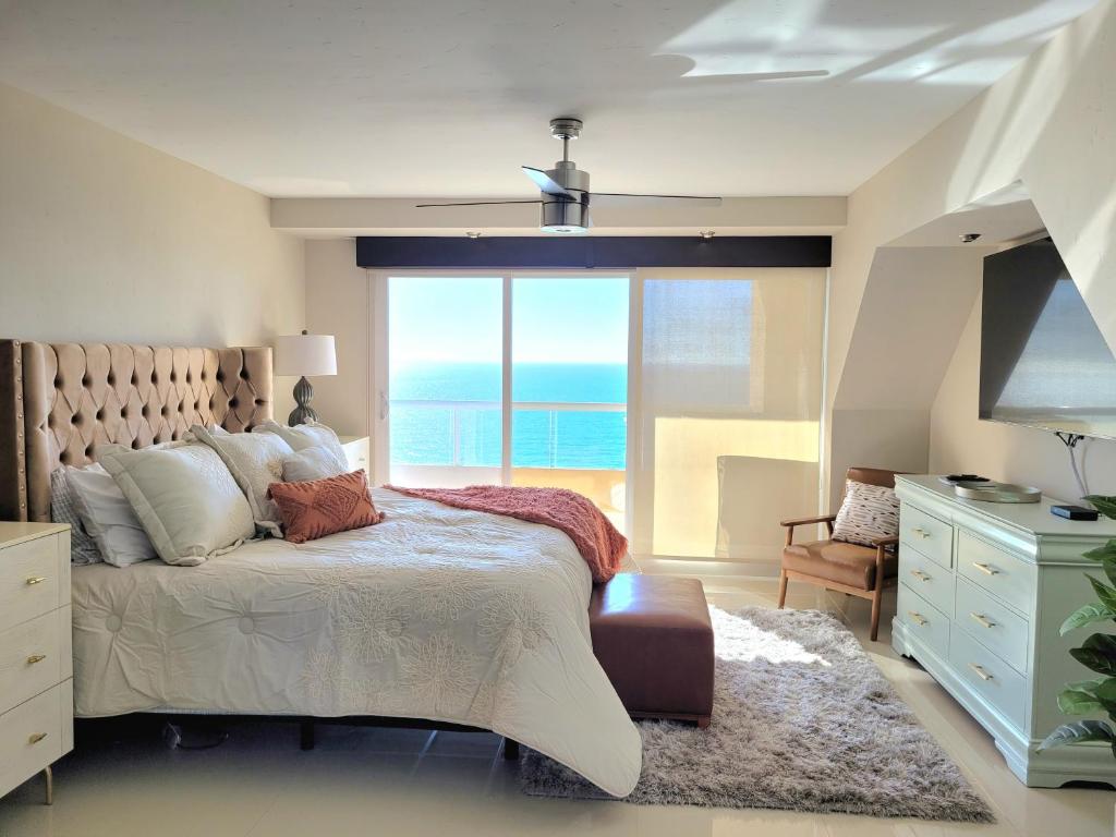1 dormitorio con 1 cama y vistas al océano en 2BD Beach Front Condo with Pool & More, en Rosarito