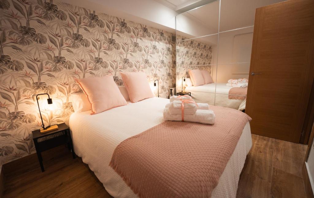 1 dormitorio con 2 camas y espejo en La Concha Pearl Beach Apartment, en San Sebastián