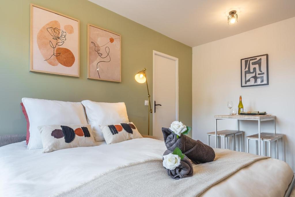 1 dormitorio con 1 cama con sábanas y almohadas blancas en L'écrin des Bois - Proche aéroport Beauvais, Chantilly, forêt de Hez-Froidmont, parking public gratuit, Wifi & Netflix, en Clermont